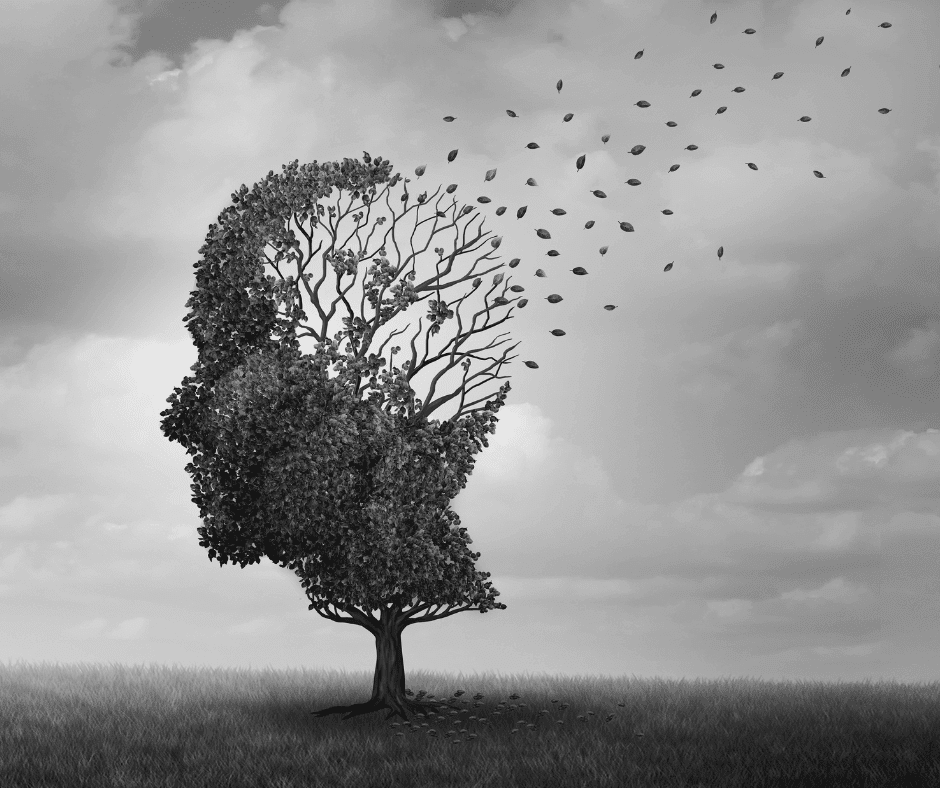 A tree in the shape of a human head stands in a grassy field; its leaves are blowing away, symbolizing memory loss or fading thoughts. The image is in grayscale, with a cloudy sky in the background.